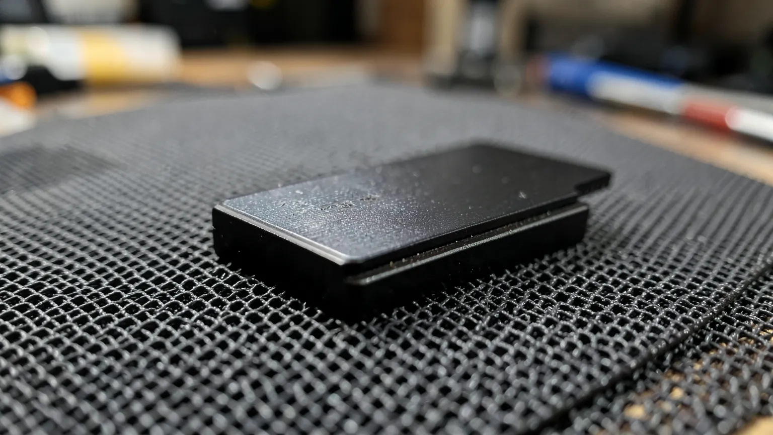 Unidad SSD M.2 con disipador metalico negro sobre una alfombrilla antiestatica de taller