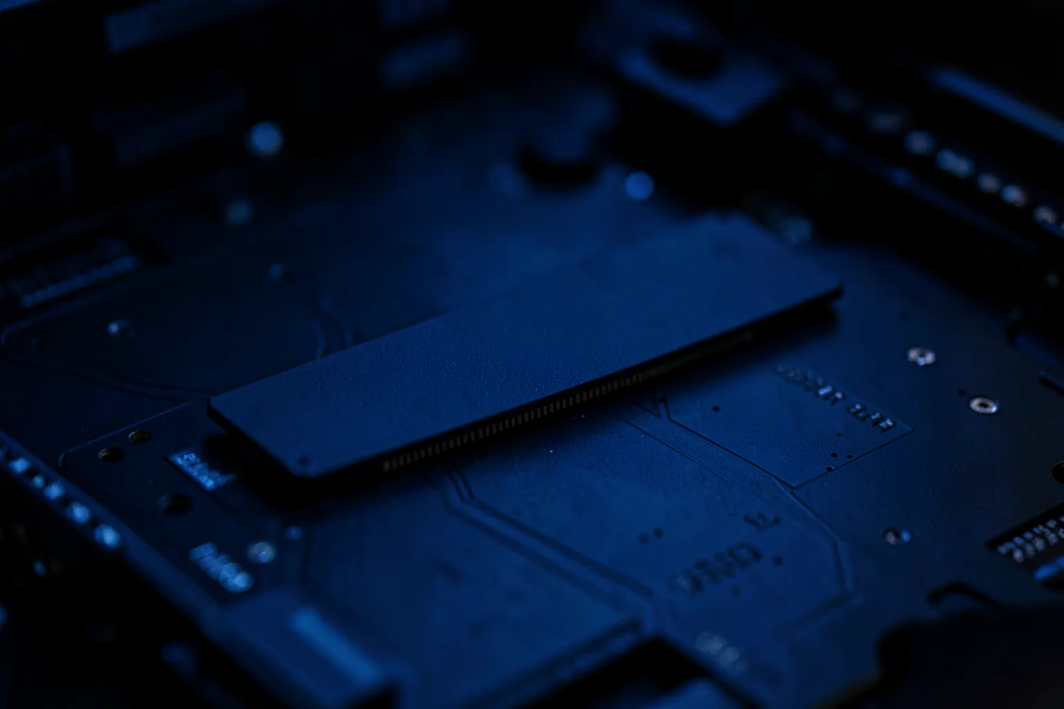 Interior de un ordenador de sobremesa con una unidad SSD M.2 instalada en la placa base bajo una luz azul tenue