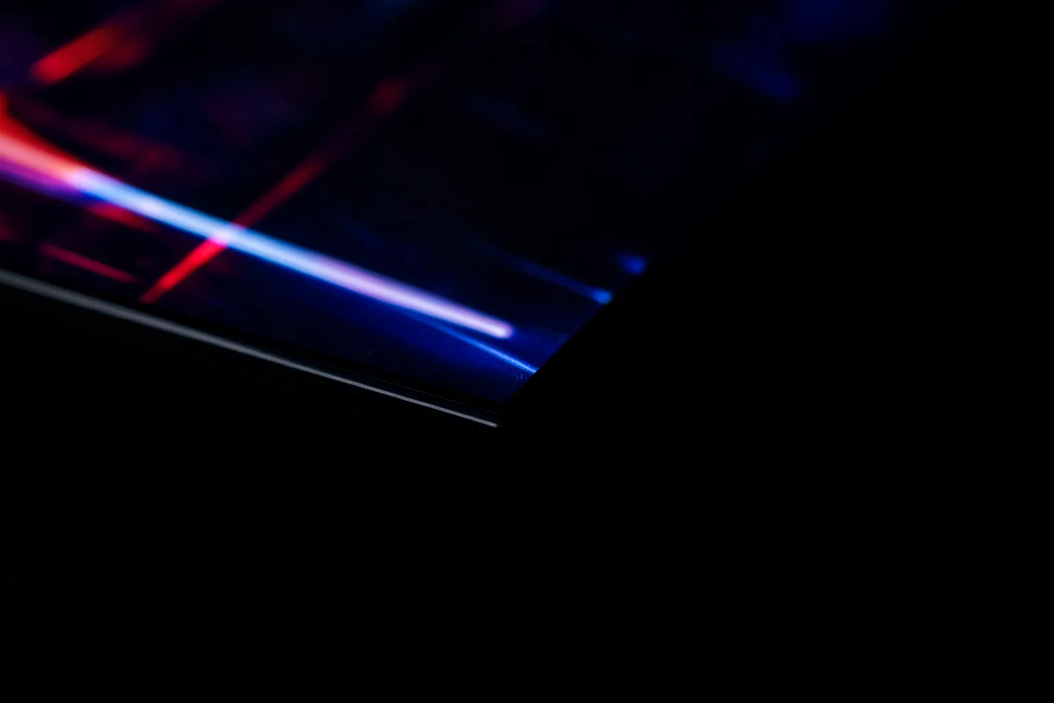Primer plano del borde ultrafino de un televisor OLED con una escena de juego oscura y brillante en la pantalla