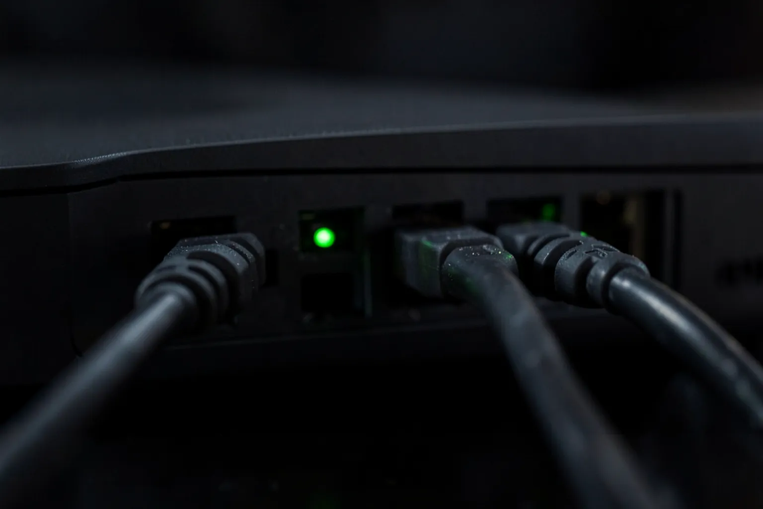 Cables de red conectados a los puertos traseros de un router doméstico con pequeñas luces verdes